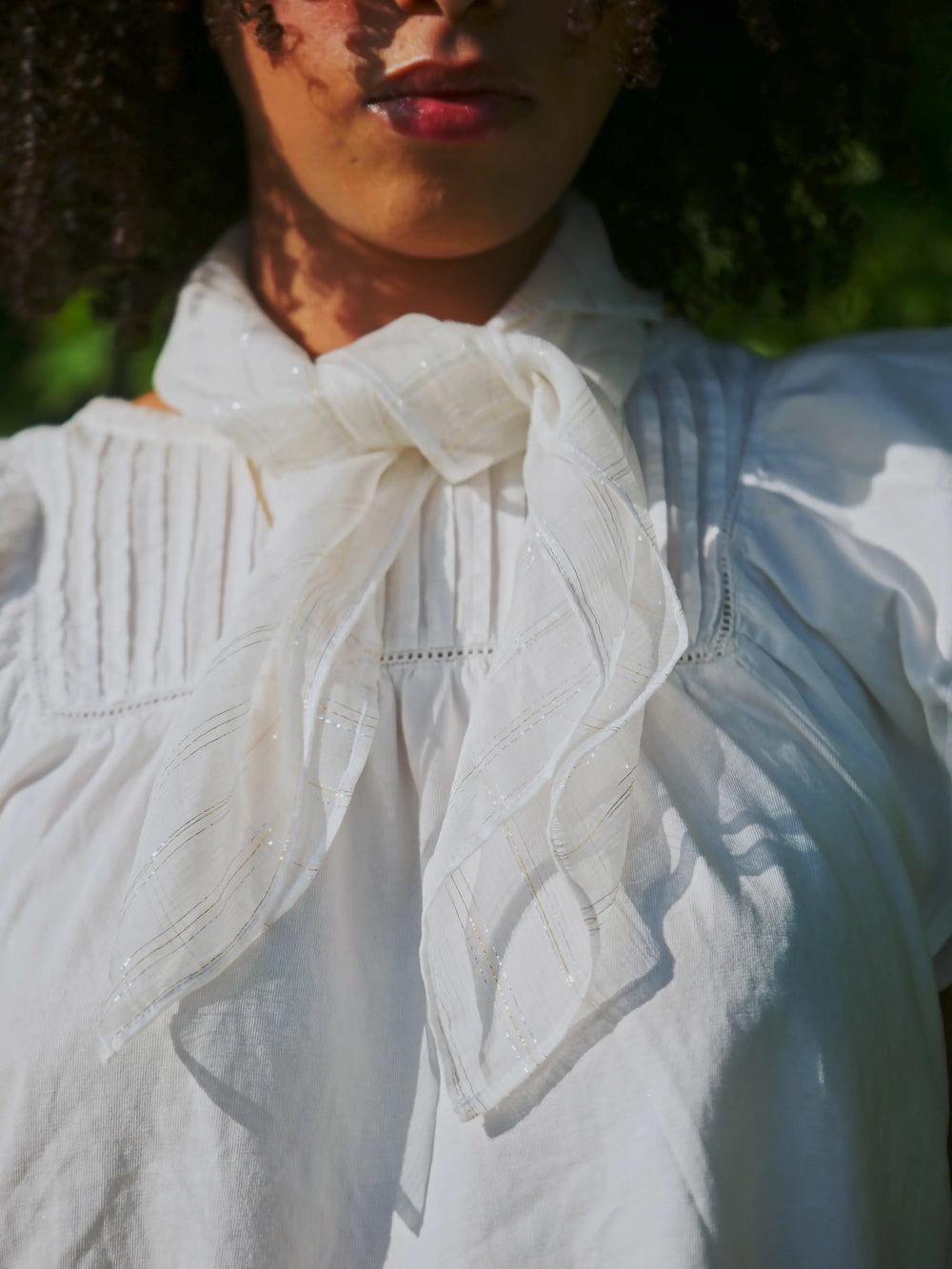 Foulard en mousseline de soie blanc fils métalliques or argent autour du cou 